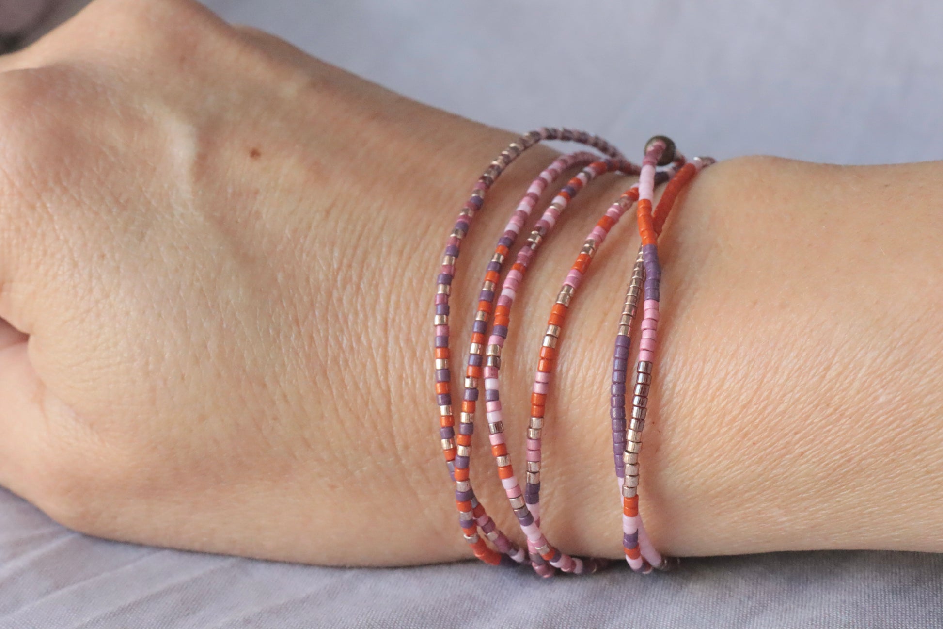 bracelet élastique en perles de verre rose et orange sur poignet
