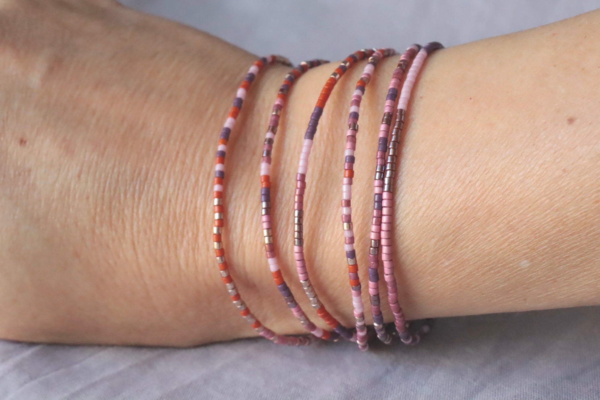 Bracelet élastique en perles roses et oranges sur poignet
