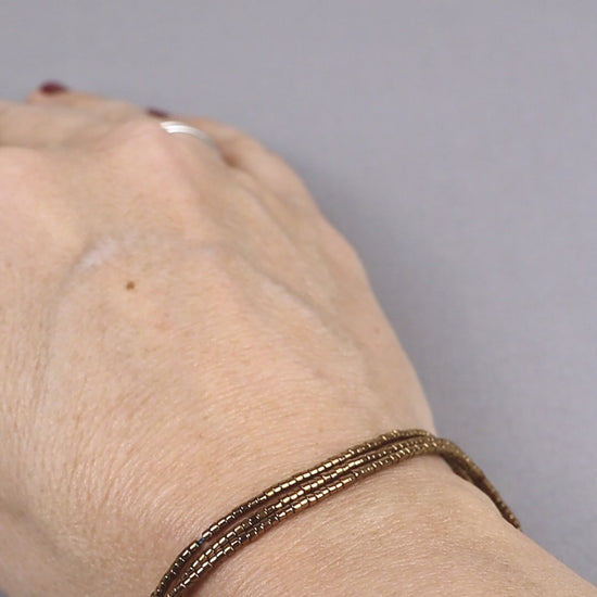 Vidéo du bracelet Abbie porté, en perles du Japon dorées montées sur des cordons en nylon couleur vert canard