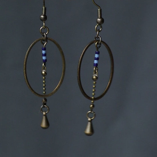 vidéo des boucles d'oreilles pendantes, modèle Alana, ovales en laiton avec des perles bleues