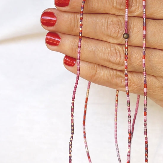 Vidéo du collier-bracelet élastique en perles de verre, tenu dans les mains, puis enroulé autour du poignet
