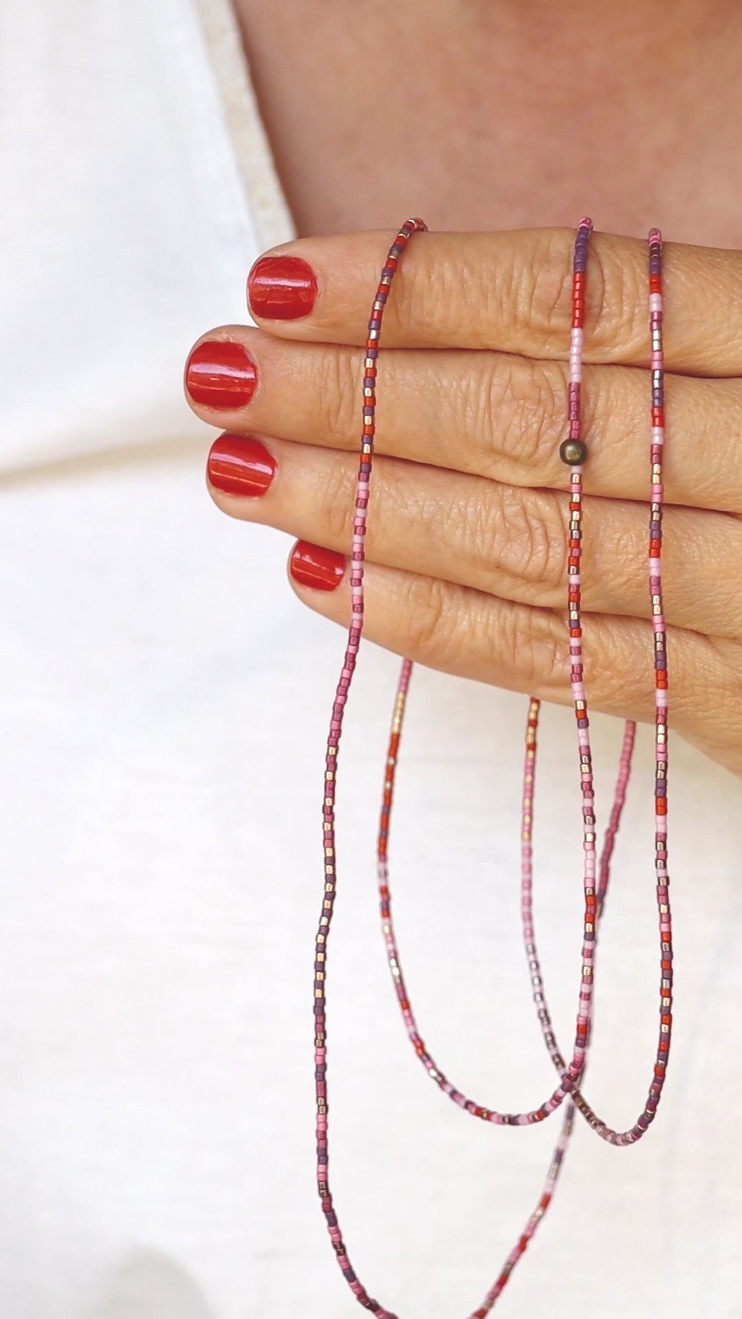 Vidéo du collier-bracelet élastique en perles de verre, tenu dans les mains, puis enroulé autour du poignet